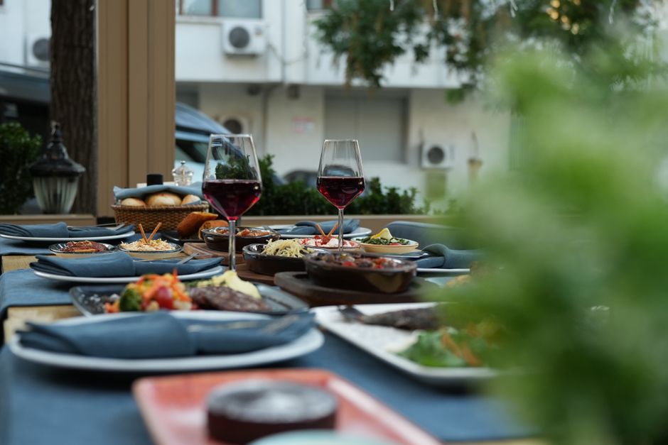 Elegantly set outdoor dining table with wine glasses and assorted dishes