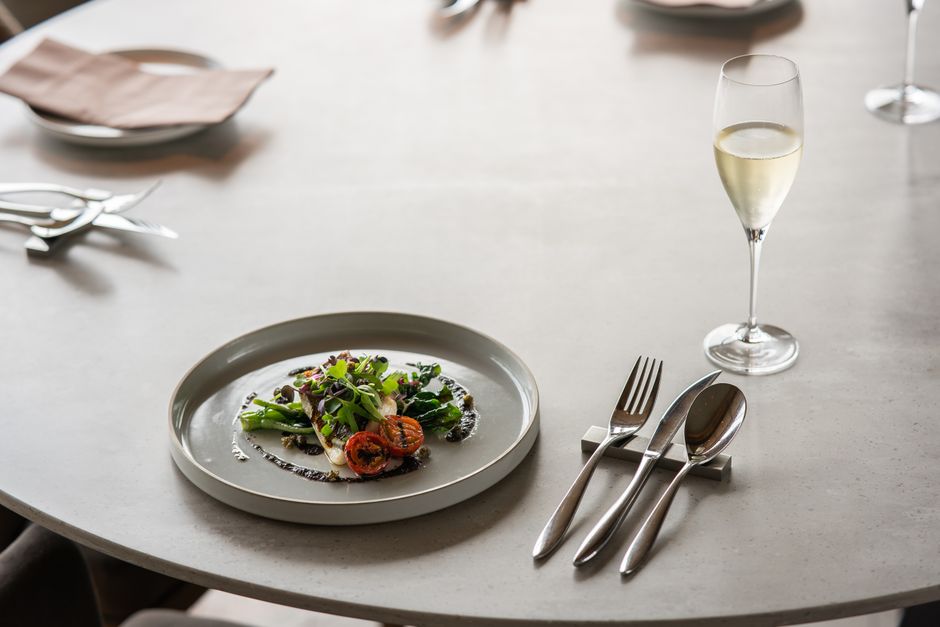 A sophisticated table setting with gourmet dish and champagne glass