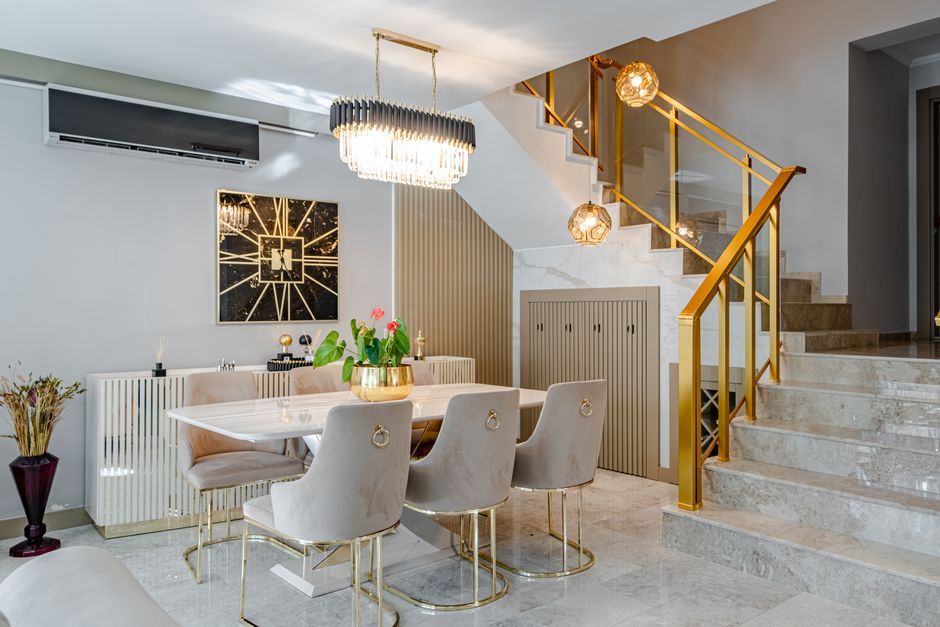 Modern dining room with marble table, gold accents, and stylish lighting