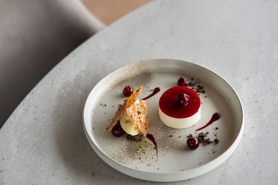 A sophisticated dessert with cherry garnish presented elegantly