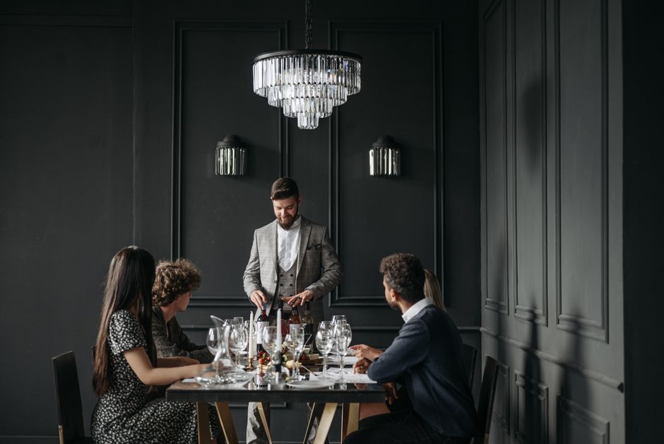 A sophisticated dinner gathering indoors with wine and elegant table setting