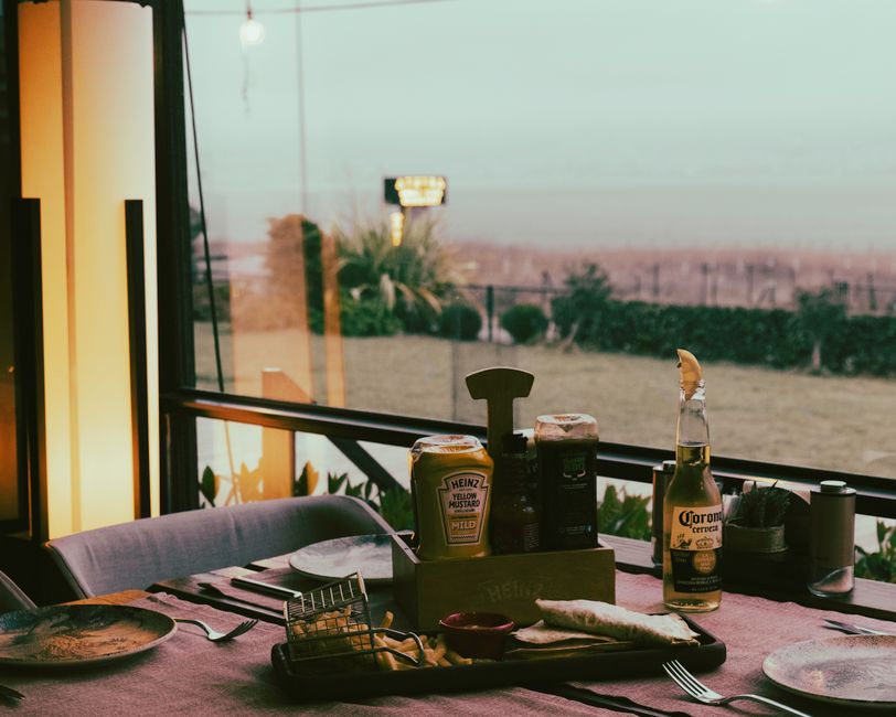 A warm and inviting restaurant table setting with condiments overlooking a scenic outdoor view