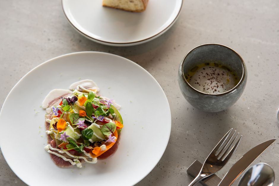 A beautifully presented artisanal salad dish with floral garnishes